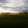 A sunny view of the driving range at Desert Sands Golf Course