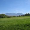 A view of a green with mountains in background at San Ignacio Golf Club
